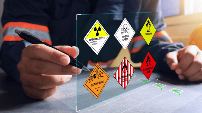 Person analyserer forskjellige faresymboler for farlige materialer på en gjennomsiktig skjerm.