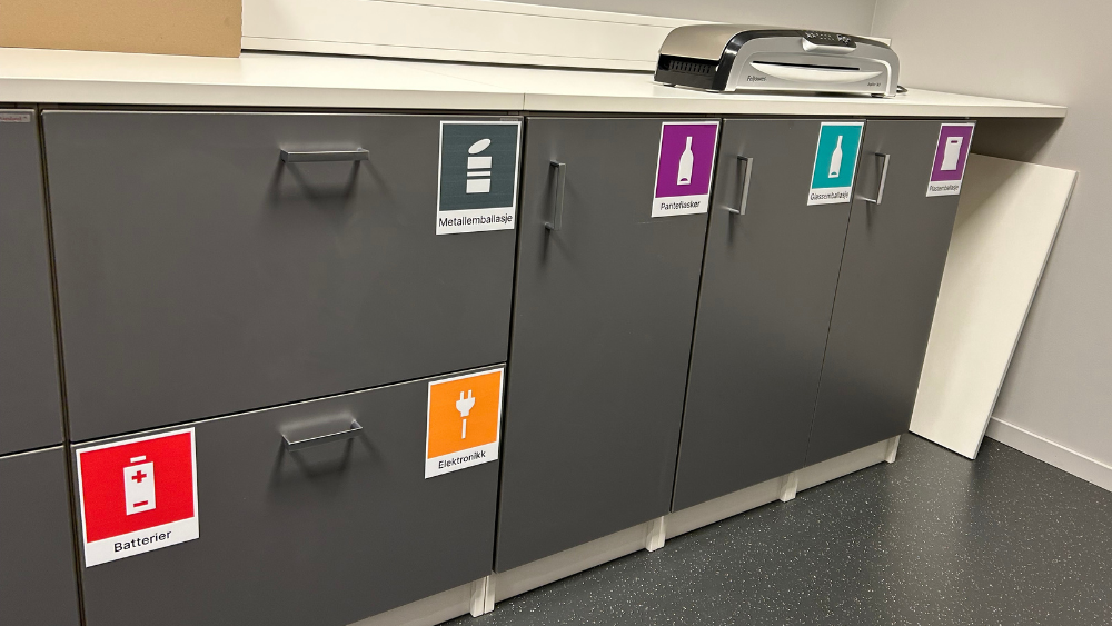 Skap for kildesortering med tydelige merker for batterier, metall, elektronikk og flasker