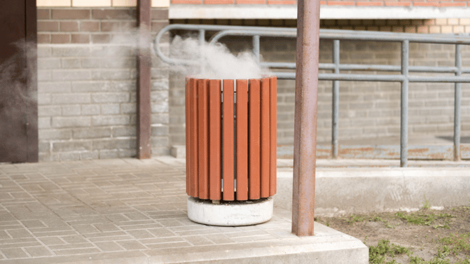 1.	Røyk stiger opp fra en offentlig avfallsbeholder, noe som kan tyde på ulmende brann.