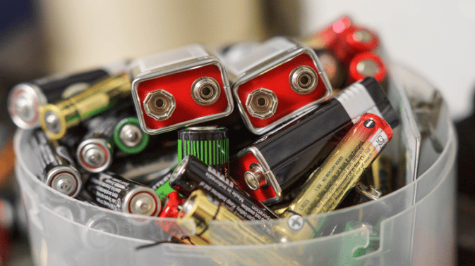 Brukte batterier i en plastbeholder.