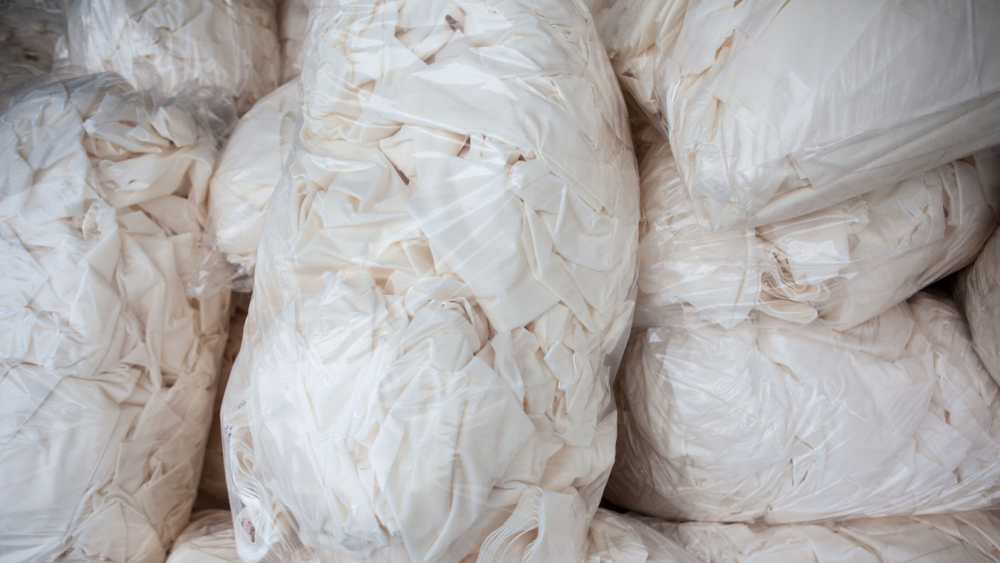 Grovsorterte tekstiler pakket i klar plastsekk klar for gjenvinning
