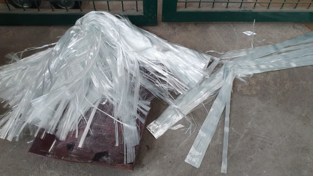 Strimler av glassfiberavfall på betonggulv.