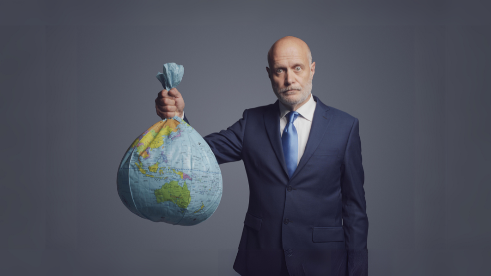 Mann holder en ballong med motiv av jorden, i form av en søppelsekk.