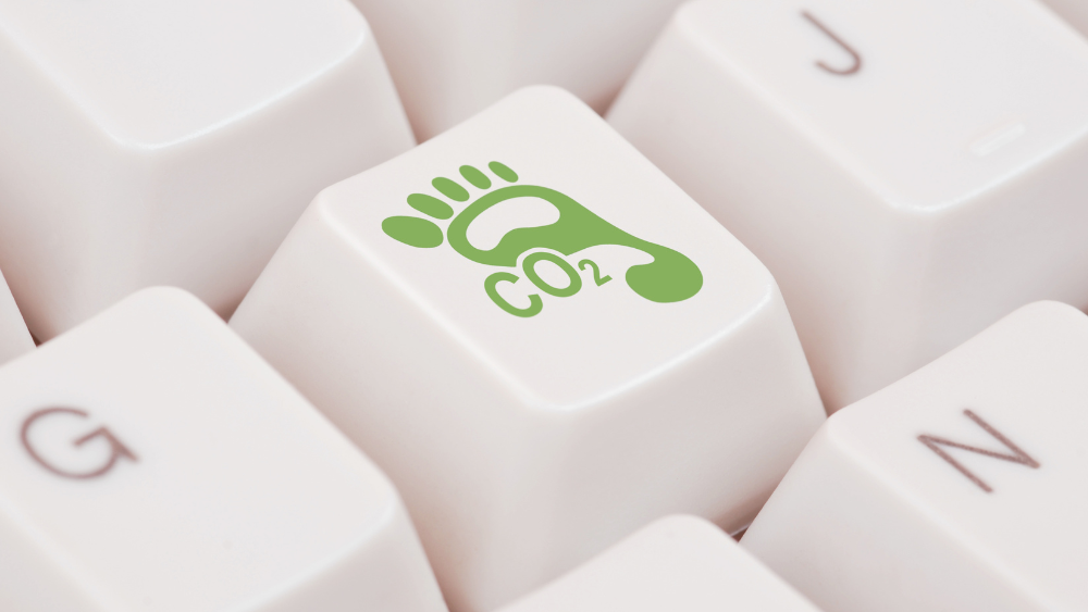 Tastatur med illustrasjon av grønt fotavtrykk og CO2 skrevet på en av tastene.