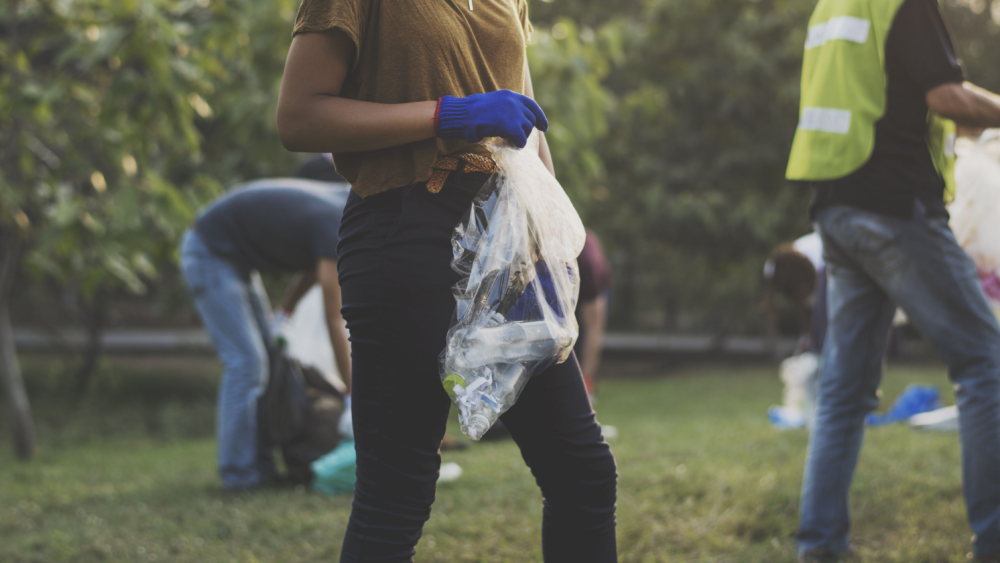 Mennesker samler inn avfall på en gressplen